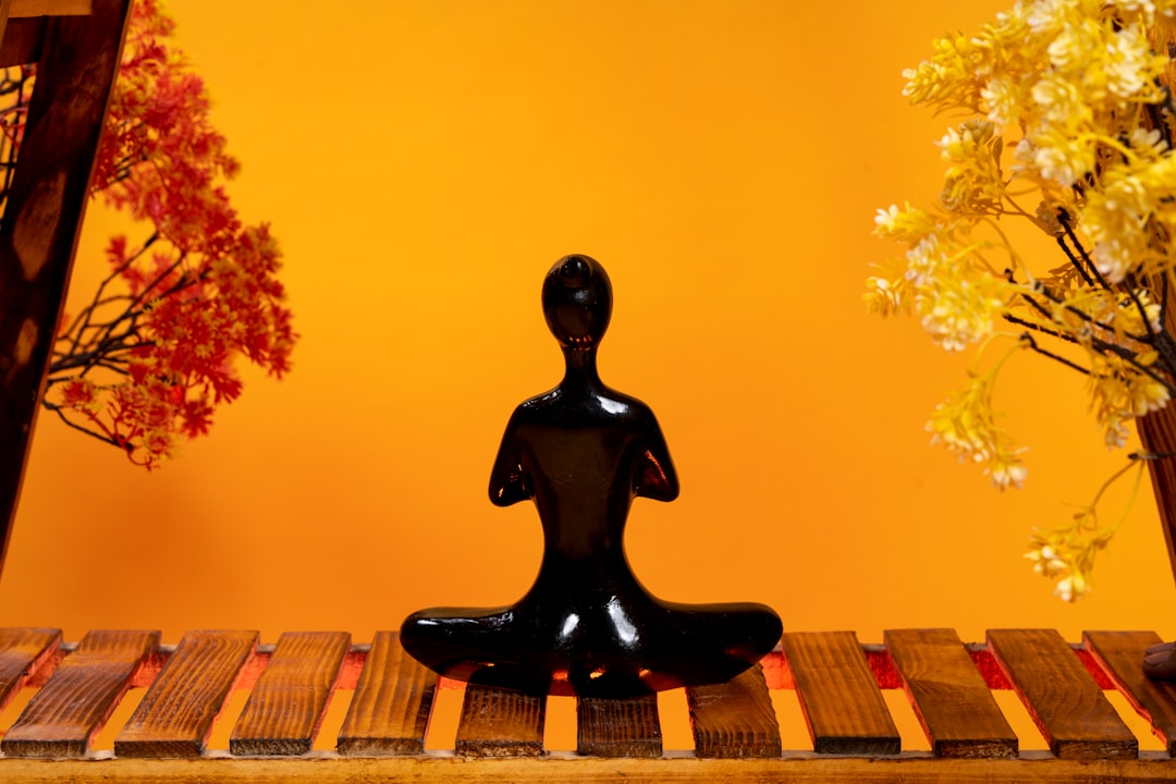 a-black-statue-sitting-on-top-of-a-wooden-table-z-vzpw5nbdu